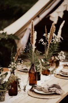 the table is set with flowers and bottles