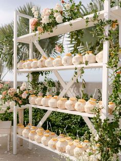 an outdoor wedding with cupcakes and greenery on the shelves in front of them