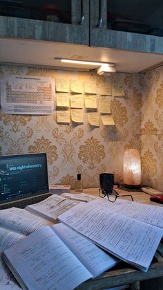 there are many sheets of paper on the table next to a laptop computer and lamp