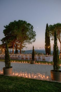 an outdoor dining area with candles and trees