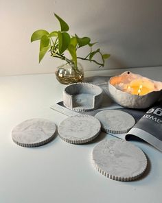 some cookies are sitting on a table next to a potted plant and a candle