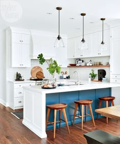 a kitchen with white cabinets and blue island in the center is surrounded by wooden stools