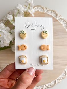 a pair of earrings is shown in front of a card with the words wild honeys on it