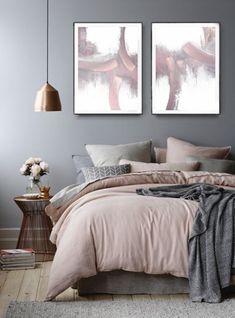 a bedroom with two pictures on the wall and a bed covered in pink linens