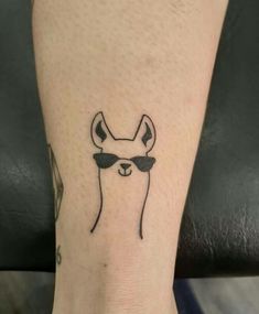 a tattoo on the leg of a person wearing sunglasses and a deer head with horns