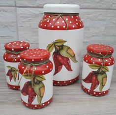 four red and white jars with designs on them