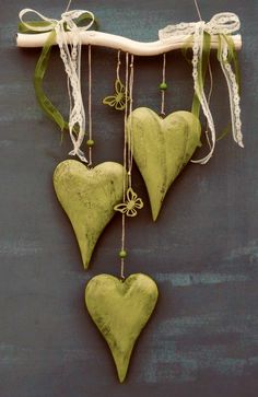 three green heart shaped ornaments hanging on a wall