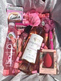 a bag filled with lots of different types of cosmetics and hygiene products on top of a bed