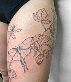 a woman's thigh with flowers and dragonflies on it