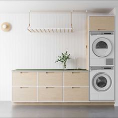 a washer and dryer in a white room with wooden cabinetry on the wall