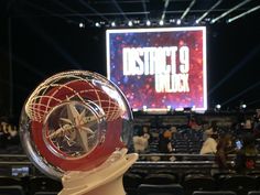 a person holding up a trophy in front of a large screen with the words district 9 rock on it