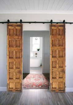 an open door leading to a bathroom with a rug on the floor in front of it