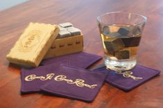 a glass of water and some coasters on a table