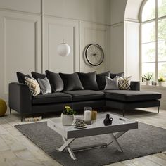 a living room with a sectional couch and coffee table in front of a large window