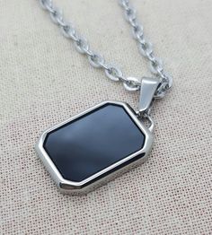 Rectangle imitation onyx pendant necklace. Stylish, minimalist jewellery for men. Simple and discreet, suitable for casual or formal wear. Great gift for men, birthdays, christmas, anniversaries. Pendant 21mm x 15mm. With 3mm flat cable chain or 2mm box chain. Available in various lengths to suit all tastes. Premium  stainless steel -  * Durable * Waterproof * Hypoallergenic * Tarnish and scratch resistant * High strength * Lasting colour * Shiny  * Comfortable to wear * Affordable  We keep pack Rectangular Stainless Steel Necklaces, Modern Black Jewelry With Rectangular Stone, Formal Black Rectangular Necklace, Black Rectangular Stainless Steel Jewelry, Black Stainless Steel Rectangular Jewelry, Rectangular Black Necklaces For Gifts, Black Rectangular Necklace Gift, Black Jewelry With Rectangular Stone For Gift, Modern Black Necklace With Square Pendant