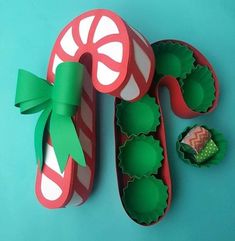 candy canes and christmas decorations made out of paper on a blue background with green ribbon