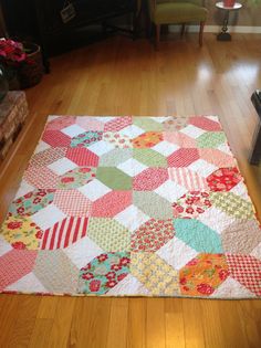 a patchwork quilt on the floor in a living room