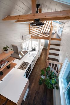 an overhead view of a kitchen and living room in a tiny house with stairs leading up to the second floor