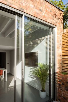 a house with large sliding glass doors and brick walls