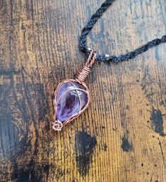 Amethyst Wrapped in Copper Wire and hung on a Black Macrame Chain. ☆ A one off, completely unique piece ☆ Gorgeous amethyst stone. Hand made macrame cord. Hand wrapped copper wire.  Adjustable length!  All of my pieces are 100% vegan to the best of my knowledge.  I put a lot of thought into where I buy materials from and how I package and send out my products to have the least impact on the earth. I ask that you re use and recycle any packaging that you recieve.  Follow SoulTideJewellery on Inst Adjustable Amethyst Crystal Necklace As Gift, Adjustable Amethyst Crystal Necklace For Gift, Adjustable Hand Wrapped Amethyst Necklace, Handmade Adjustable Amethyst Necklace, Unique Adjustable Amethyst Necklaces, Adjustable Amethyst Crystal Necklace, Purple Adjustable Cord Jewelry As Gift, Purple Jewelry With Adjustable Cord As Gift, Bohemian Hand Wrapped Purple Necklace