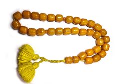 a yellow beaded necklace with a tassel