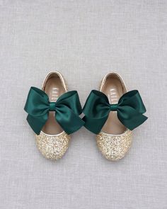 two pairs of shoes with green bows on the front and bottom, one in gold glitter