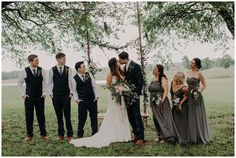 a group of people standing next to each other in front of a tree with flowers