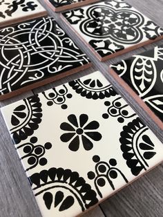 four black and white tiles sitting on top of a wooden table