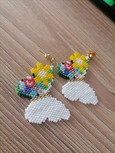 a pair of beaded earrings on top of a wooden table