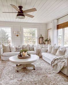 a living room filled with white furniture and pillows on top of a carpeted floor