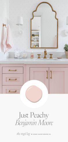 a bathroom with pink cabinets and gold accents, including a large mirror above the sink