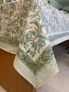 an image of a table cloth on top of a wooden stand in a room with white tile flooring