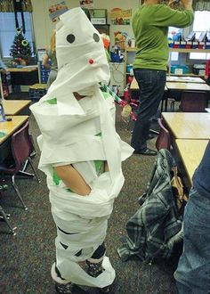 a person standing next to a pile of paper wrapped in tape and wearing roller skates