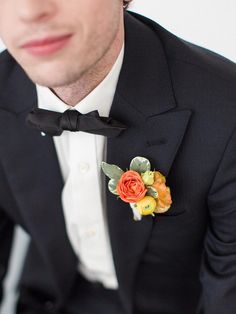 a man in a tuxedo with a boutonniere on his lapel