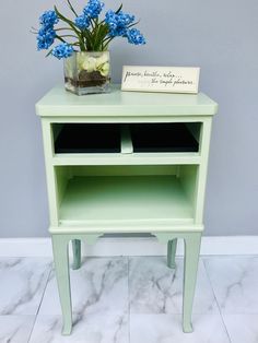 a small green table with some flowers on it