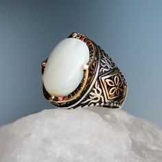 "White Mother of Pearl Stone Silver Ring, Handmade Sterling Silver Ring, 925 Silver Handmade Mens Ring, Unique Gemstone Vintage Style Gift for Him The middle stone is Mother of Pearl Aquamarine. Red micro stones between the decorative motifs on the arms of the ring creates a magnificent aesthetic to the ring. About Mother of Pearl Gemstone: Mother-of-pearl is a limestone substance composed of salt, lime and phosphorus in the flowing waters of warm seas. There are varieties such as white, arusek, Vintage White Rings With Accent Stones, White Opal Ring With Stone Setting As A Gift, White Gemstone Signet Ring Gift, White Oval Gemstone Signet Ring, Antique White Moonstone Ring, White Oval Heirloom Signet Ring, Heirloom White Oval Signet Ring, White Sterling Silver Signet Ring With Gemstone, White Gemstone Signet Ring In Sterling Silver