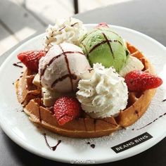 waffles topped with ice cream and strawberries on a plate