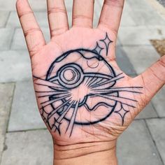 a person's hand with a tattoo on it that looks like an eyeball