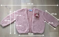 a pink sweater with a flower on the back and measurements for it to be worn