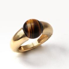 "Tiger Eye Geometric Cocktail Ring. FREE EXPRESS SHIPPING! Your new jewelry direct to your door! The Donut Tiger eye stone ring's benefits are beyond words: it is an incredible stone for achieving clarity. Traditionally carried as a talisman, this tiger ring is hand-forged for those who are glamorous and not afraid to show it. This sweet and colorful piece can also make the perfect birthday gift. If you love this piece with its inspiring tiger eye design, then you'll love our Blue round stone ri Modern Gold Jewelry With Round Stone, Modern Gold Signet Ring With Cabochon, Modern Yellow Gold Cabochon Rings, Modern Gold Crystal Ring With Gemstone, Modern Gold Stackable Gemstone Rings, Modern Gold Stackable Rings With Gemstones, Modern Stackable Gold Rings With Gemstones, Modern Yellow Gold Dome Ring With Cabochon, Modern Brown Rings For Anniversary