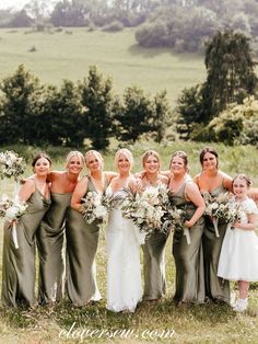 a group of women standing next to each other on top of a lush green field