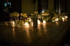 candles and flowers are lit up on a table