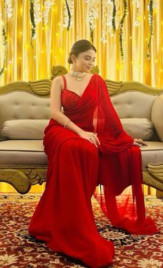 a woman in a red dress sitting on a couch