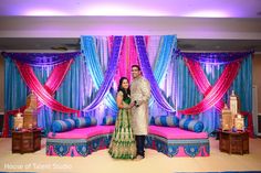 a man and woman standing in front of a stage set up for a wedding ceremony