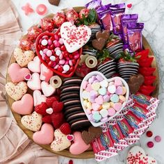 a platter filled with heart shaped chocolates and candy