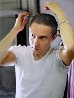 black and white photograph of a young man combing his hair