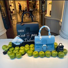 an assortment of bags and apples on display in a mall