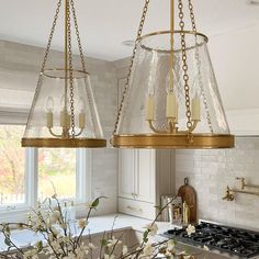 two chandeliers hanging from the ceiling in a kitchen