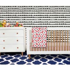 a white crib in front of a black and white wall