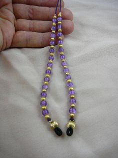 "(Internal #E-71) This is an eyeglass leash holder with round LIGHT PURPLE crackle glass beads (13 beads on each side) accented with round gold tone brass bead spacers, on purple cording, average 30\" long. Hand crafted and serve two purposes - they keep you from losing your glasses, and they look like earrings when you've got your glasses on! Loops slip on eyeglass arms, cording behind your neck. Keep your glasses on, or rest them on your chest - you've got them on a leash! Hand crafted and ONE Gold Beaded Glasses Chains, Handmade Gold Glasses Chains With Round Beads, Gold Single Strand Adjustable Glasses Chain, Gold Adjustable Single Strand Glasses Chain, Gold Glasses Chains With Lobster Clasp And Round Beads, Purple Choker, Eyeglass Necklace, Flower Choker Necklace, Silver Brooch Pin